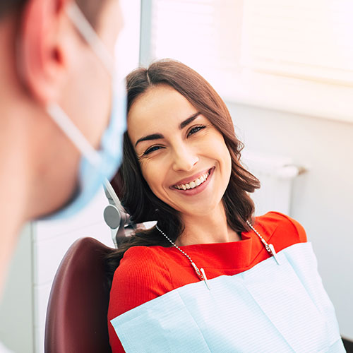 Patient in dental chair in discussion with dentist in Brampton