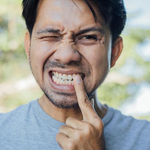 man feeling sudden pain in teeth before root canal treatment in brampton